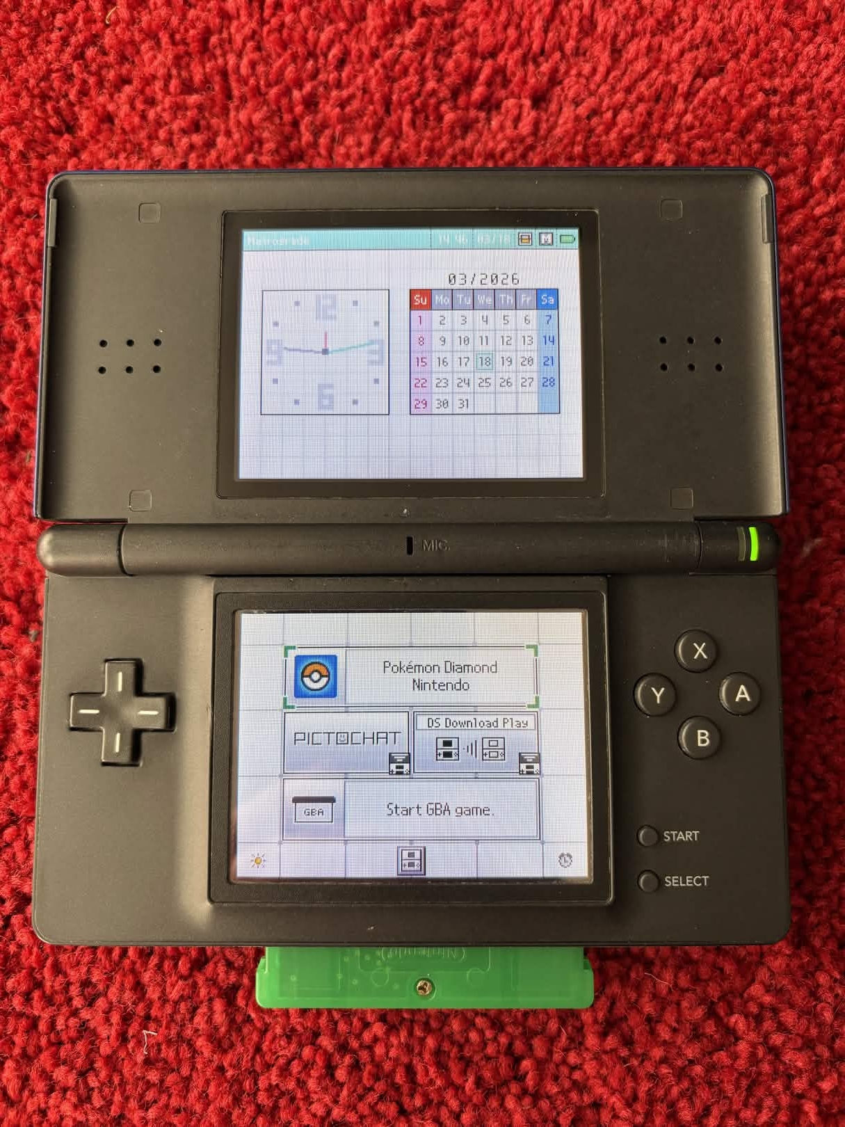 A photo of a Nintendo DS Lite with a Game Boy game inserted