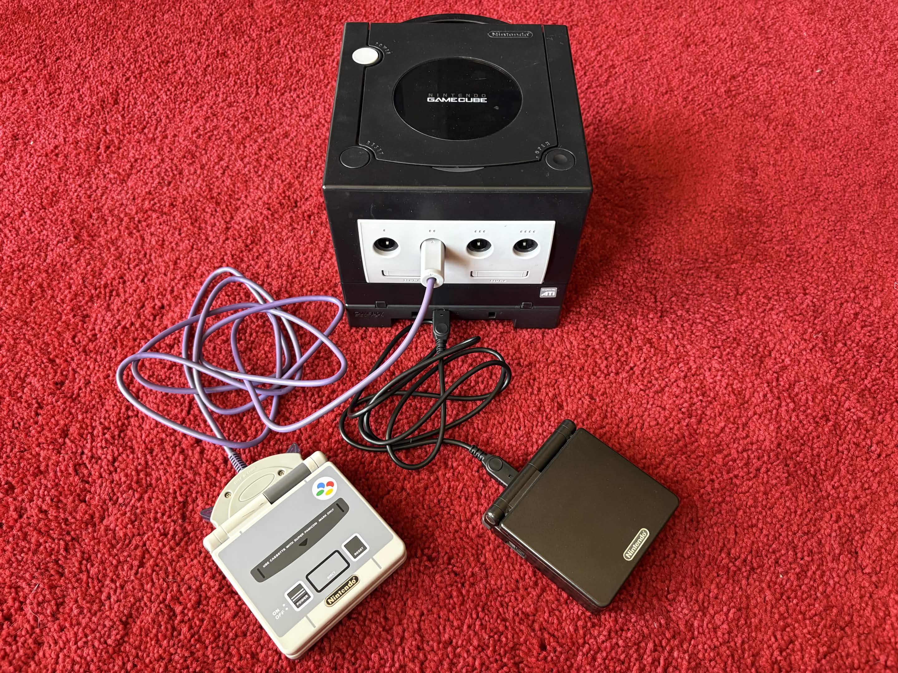 A photo of a Nintendo GameCube connected to Game Boy Advance consoles