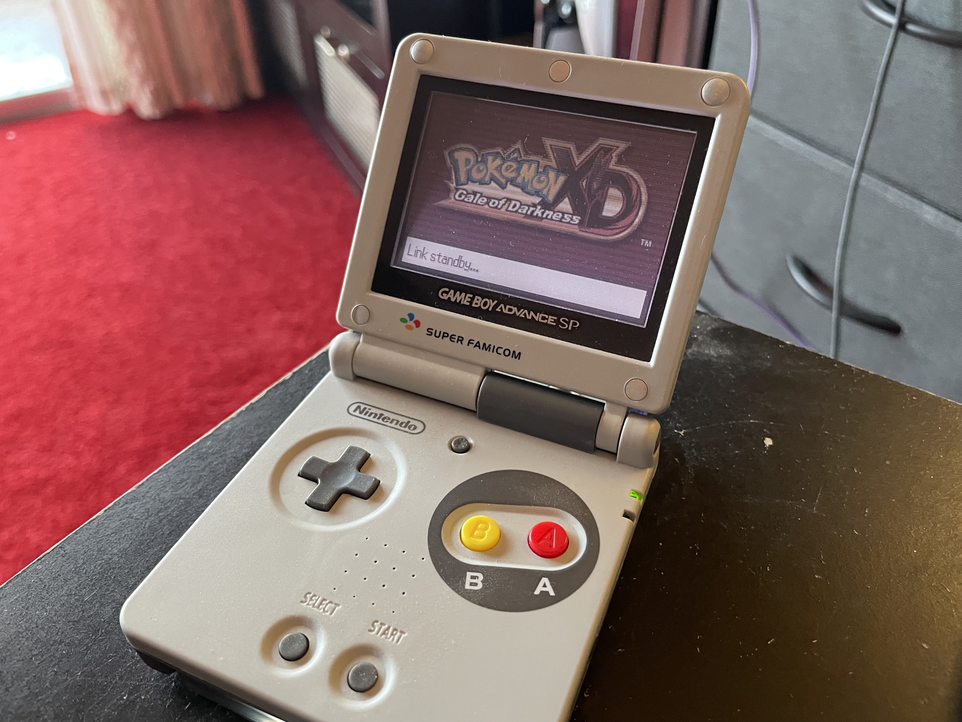 A Game Boy Advance displaying a screen linking to Pokémon XD
